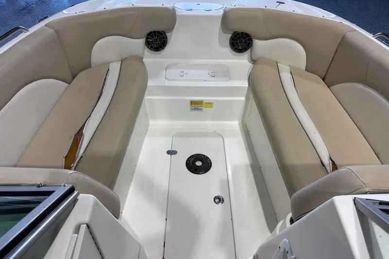 Slide: The Image of 2015 NauticStar 223DC Sport Deck interior with beige seating and storage compartments. - 12
