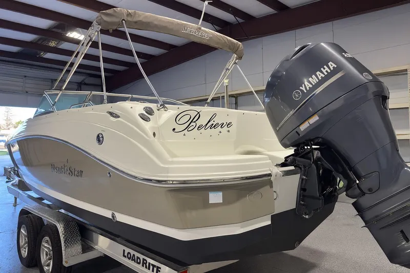 Slide: The Image of 2015 NauticStar 223DC Sport Deck boat with Yamaha engine on trailer in garage. - 2