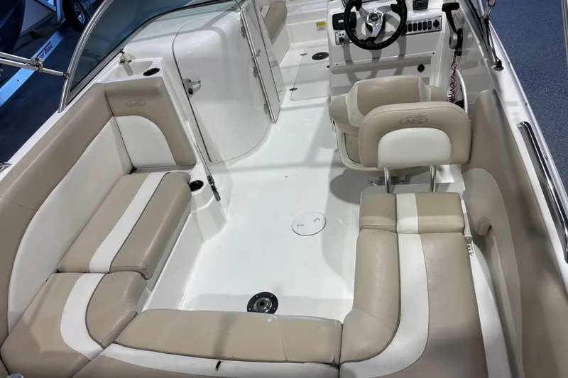 Slide: The Image of 2015 NauticStar 223DC Sport Deck interior with beige and white seating, steering console. - 5