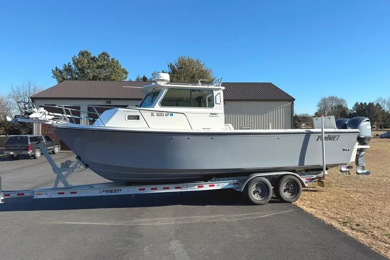 The Image of 2024 Parker 2820 XLD Sport Cabin boat on trailer, parked outdoors. - 1
