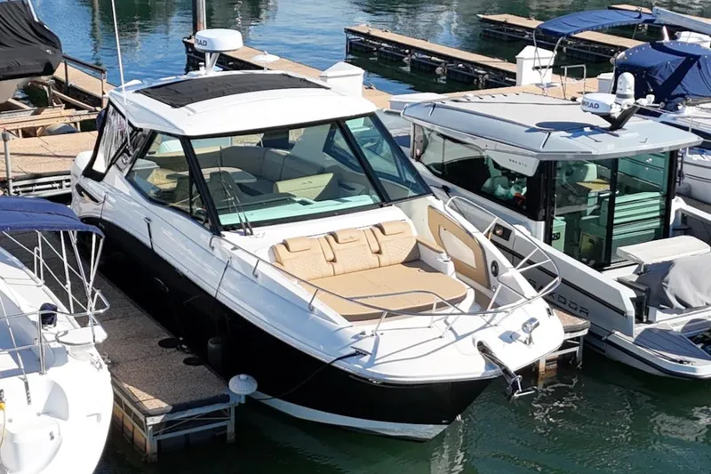 Slide: The Image of 2023 Sea Ray Sundancer 320 Outboard docked at marina, featuring sleek design and spacious seating. - 1