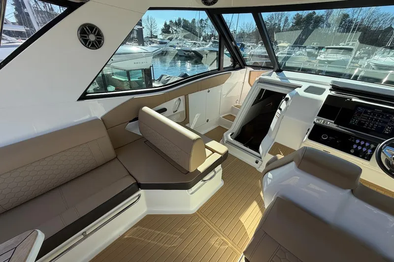Slide: The Image of 2023 Sea Ray Sundancer 320 Outboard interior with beige seating and modern dashboard. - 17