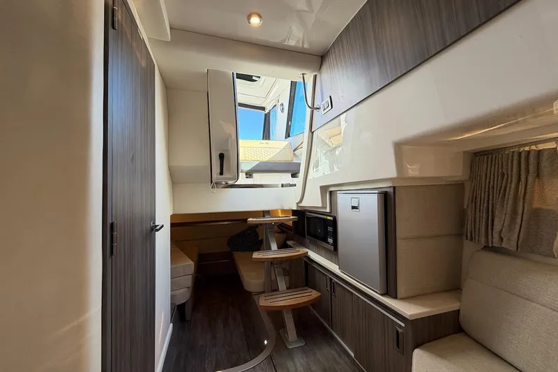 Slide: The Image of 2023 Sea Ray Sundancer 320 Outboard interior with modern kitchenette and seating area. - 29