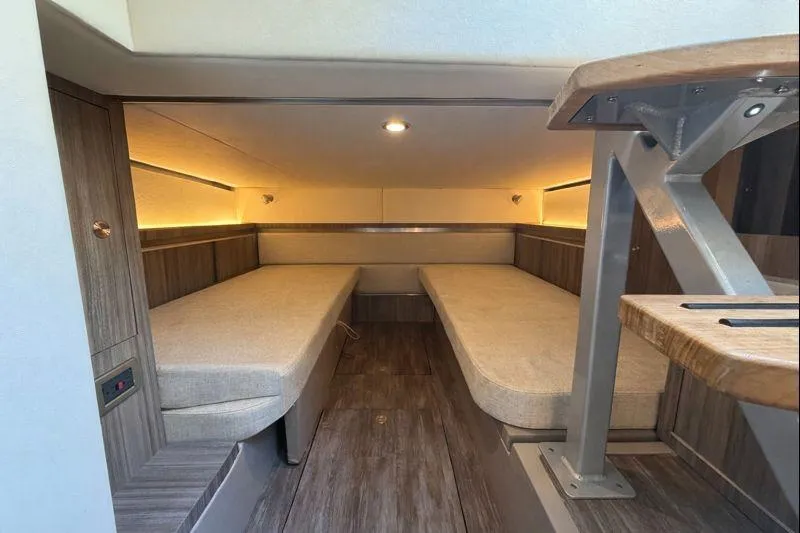 Slide: The Image of 2023 Sea Ray Sundancer 320 Outboard cabin interior with twin beds and modern wood finish. - 32