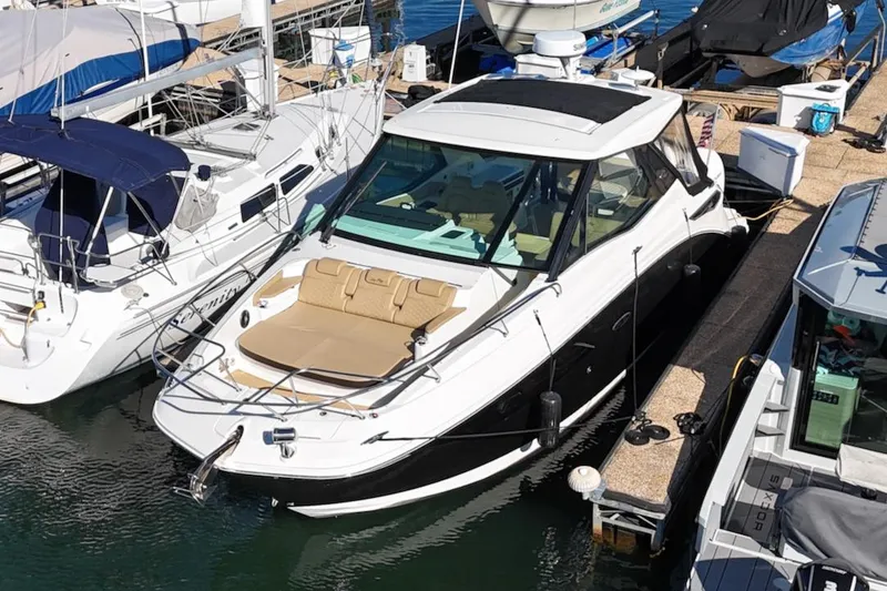 Slide: The Image of 2023 Sea Ray Sundancer 320 Outboard docked at marina, featuring sleek design and spacious deck. - 4