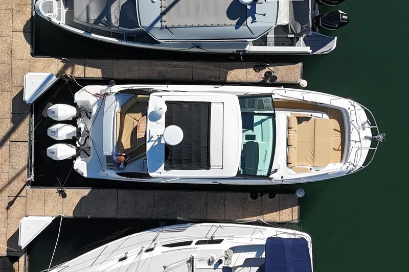 Slide: The Image of 2023 Sea Ray Sundancer 320 Outboard docked, aerial view, showcasing sleek design and spacious layout. - 6