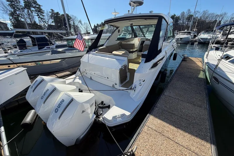 Slide: The Image of 2023 Sea Ray Sundancer 320 Outboard docked at marina with twin Mercury engines. - 7