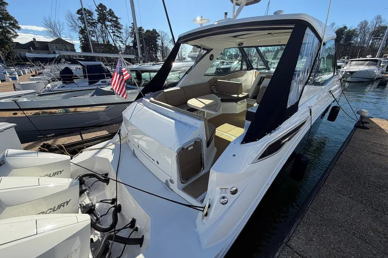 Slide: The Image of 2023 Sea Ray Sundancer 320 Outboard docked, showcasing sleek design and spacious seating area. - 9