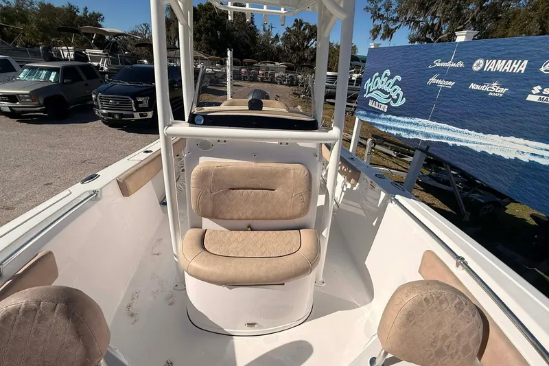 Slide: The Image of 2019 Sportsman Open 212 Center Console boat with beige seating, parked outdoors. - 7
