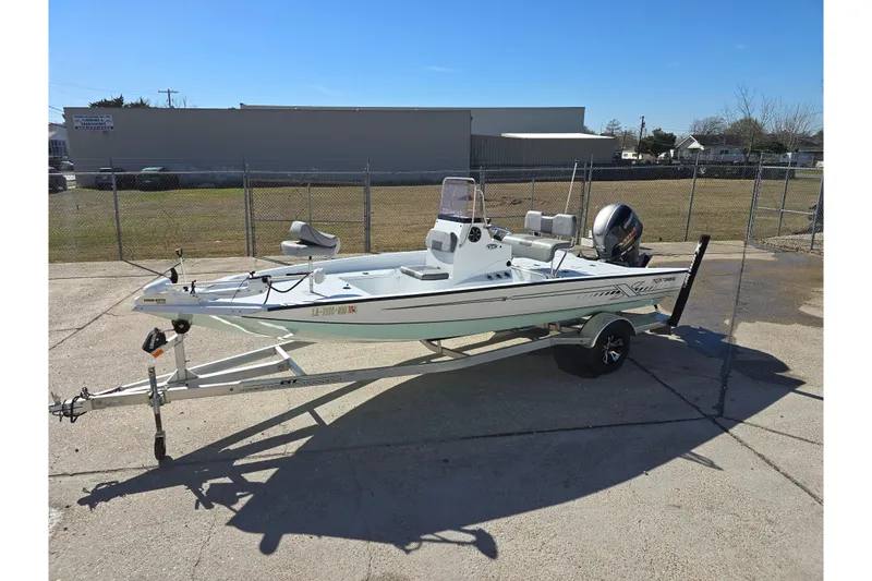 Slide: The Image of 2022 Xpress H20B Bay boat on trailer, parked outdoors under clear blue sky. - 10