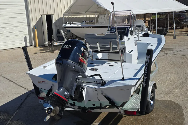 Slide: The Image of 2022 Xpress H20B Bay boat with Yamaha 115 engine, parked on a trailer. - 4