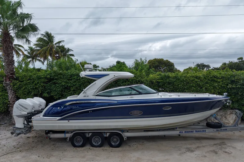 The Image of 2018 Formula 350 Crossover Bowrider OB on trailer, surrounded by lush greenery. - 1