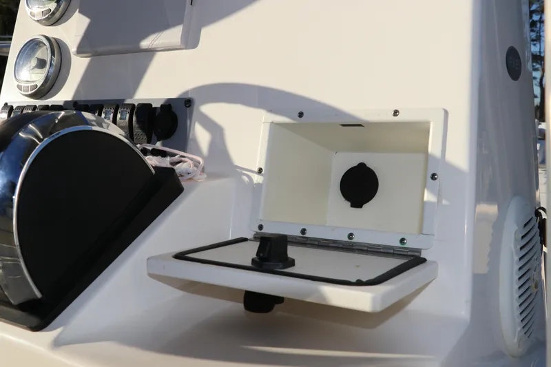 Slide: The Image of 2016 Sea Born FX21 Bay boat dashboard with open storage compartment and controls. - 13