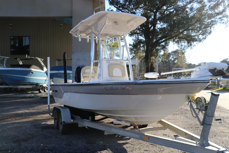 Slide: The Image of 2016 Sea Born FX21 Bay boat on trailer, parked outdoors near other boats. - 2