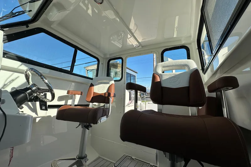 Slide: The Image of Interior of 2026 Parker 227 Explorer boat with modern seating and steering wheel. - 11