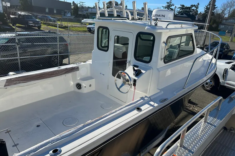 Slide: The Image of 2026 Parker 227 Explorer boat with enclosed cabin, docked outdoors. - 18