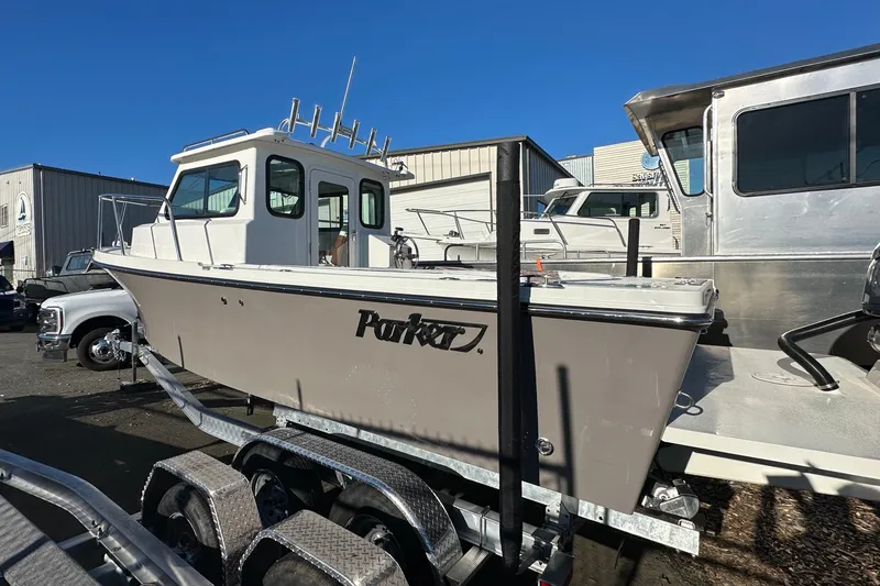 Slide: The Image of 2026 Parker 227 Explorer boat on trailer, parked outdoors under clear blue sky. - 9