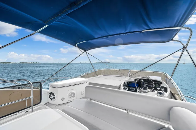 Slide: The Image of 2006 Sunseeker Manhattan 50 yacht helm with blue canopy on open water. - 21