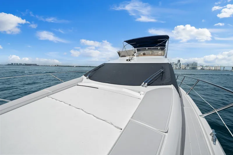 Slide: The Image of 2006 Sunseeker Manhattan 50 yacht cruising on open water under a clear blue sky. - 30