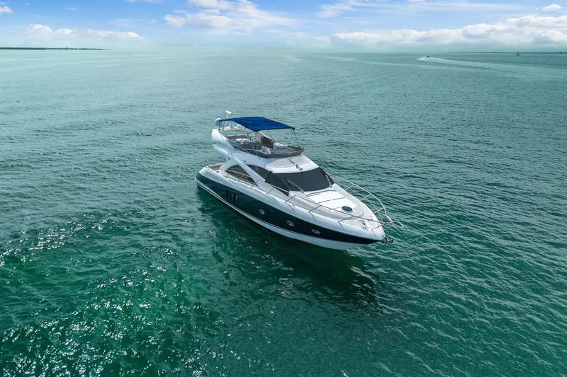 Slide: The Image of 2006 Sunseeker Manhattan 50 yacht cruising on open sea under clear blue sky. - 4