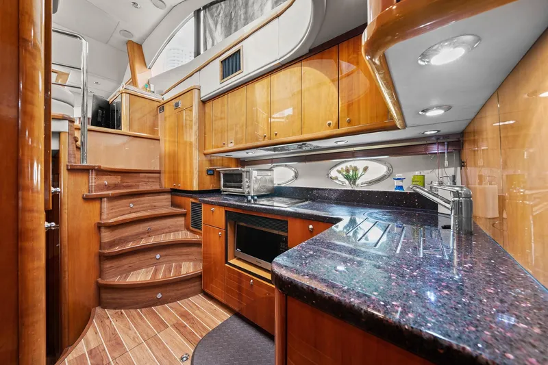 Slide: The Image of Luxurious 2006 Sunseeker Manhattan 50 yacht interior with elegant wood finishes and modern kitchen amenities. - 53