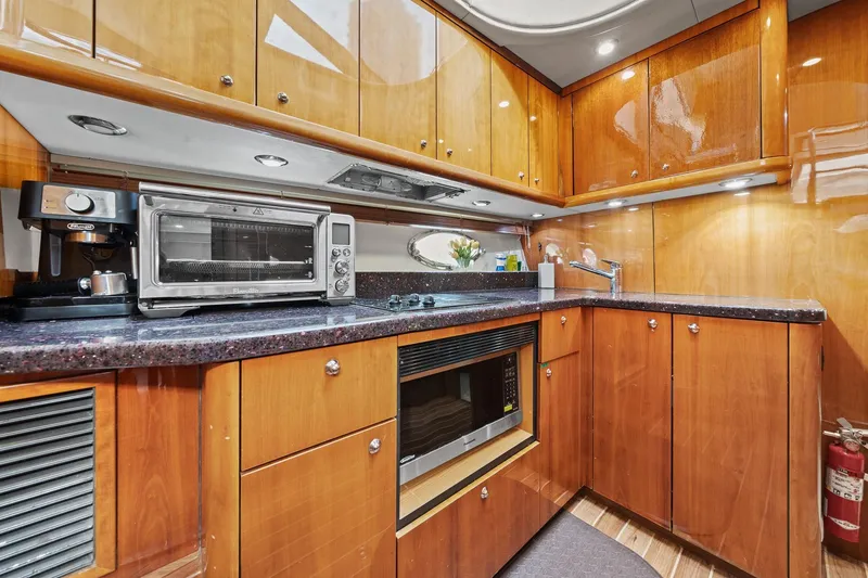 Slide: The Image of Luxurious 2006 Sunseeker Manhattan 50 yacht kitchen with modern appliances and wood cabinetry. - 55
