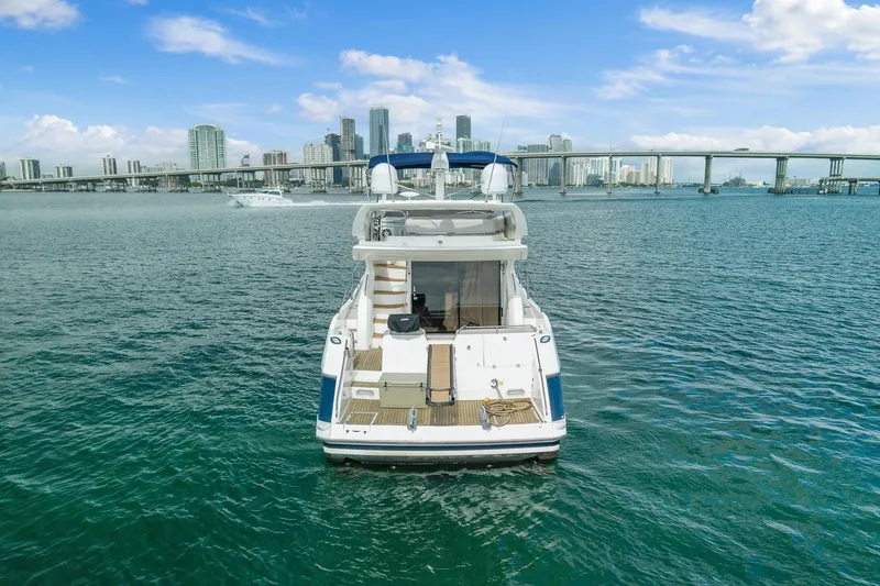 Slide: The Image of Sunseeker Manhattan 50 yacht, 2006 model, on water with city skyline and bridge background. - 6