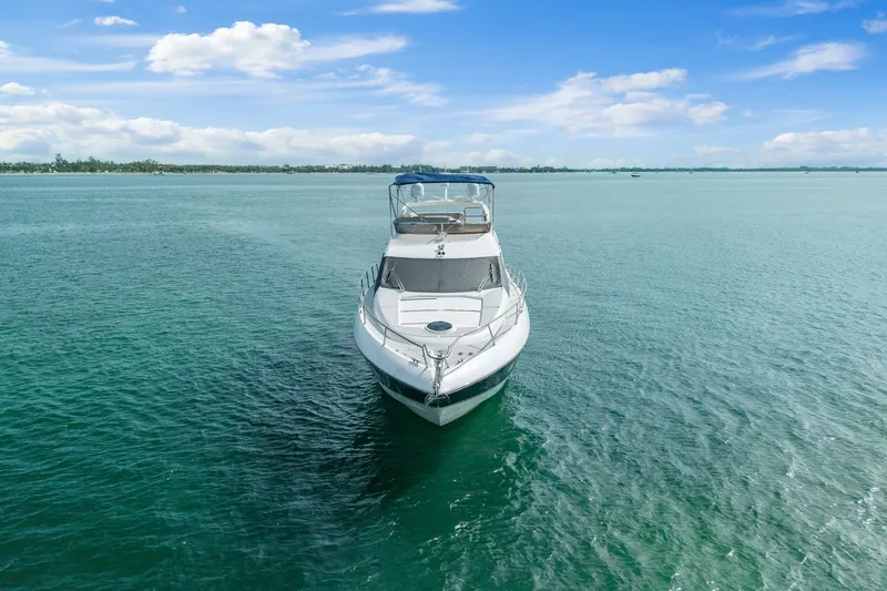 Slide: The Image of 2006 Sunseeker Manhattan 50 yacht on calm turquoise waters under a clear blue sky. - 7