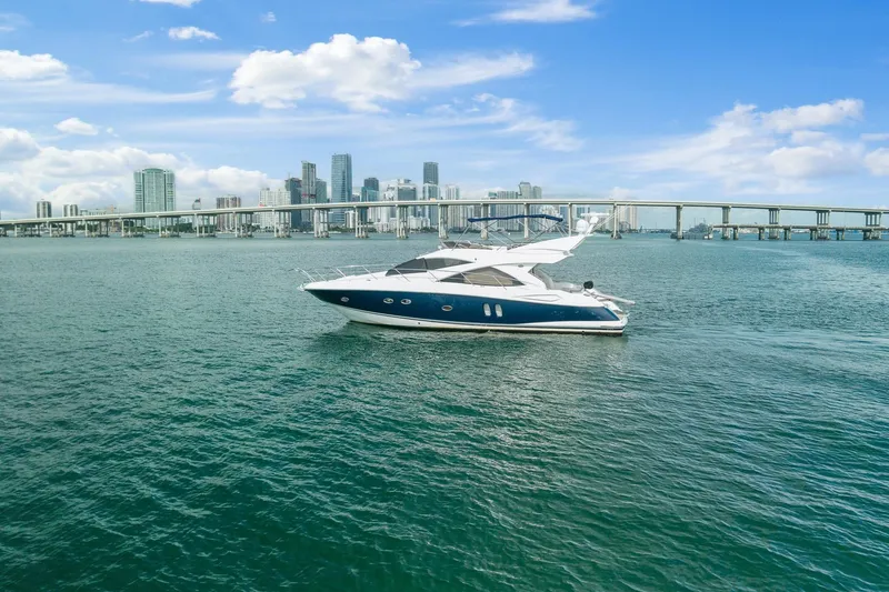 Slide: The Image of 2006 Sunseeker Manhattan 50 yacht cruising near city skyline and bridge. - 8