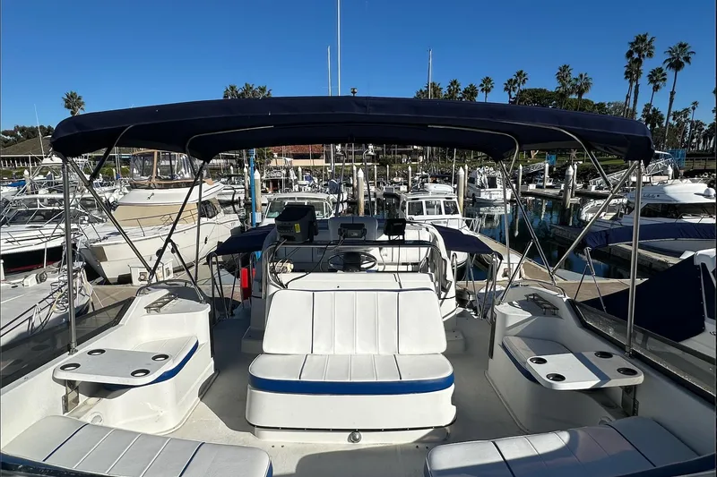 Slide: The Image of 1988 Carver 38 Santego yacht with spacious deck and seating at marina. - 11