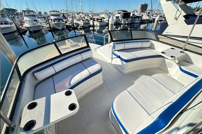Slide: The Image of 1988 Carver 38 Santego yacht with spacious seating, docked in a marina with multiple boats. - 12