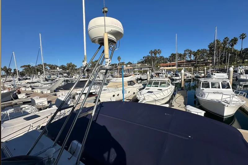 Slide: The Image of Marina with various boats, including a 1988 Carver 38 Santego, under a clear blue sky. - 15