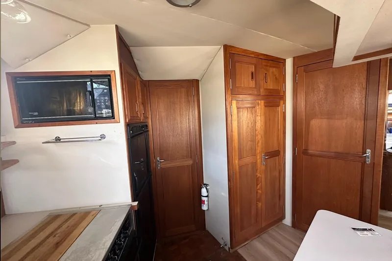 Slide: The Image of Interior of 1988 Carver 38 Santego yacht with wooden cabinetry and modern appliances. - 20