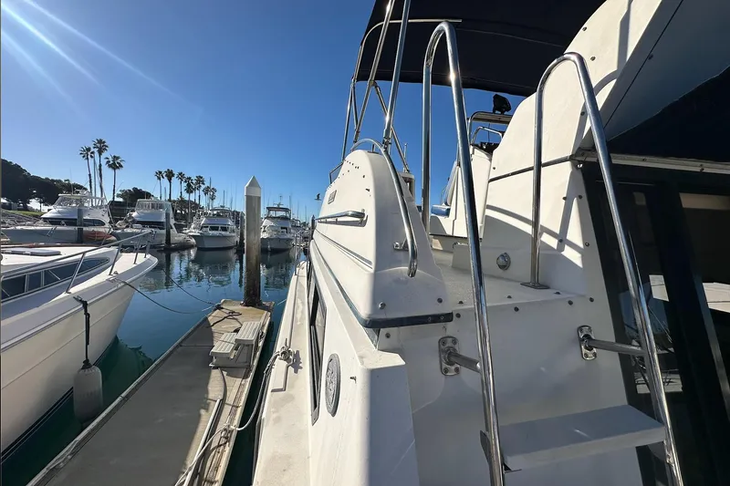 Slide: The Image of 1988 Carver 38 Santego yacht docked at a sunny marina with palm trees. - 7