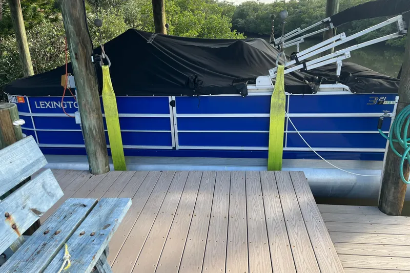 Slide: The Image of 2023 Lexington 321 CRUISE pontoon boat with Suzuki outboard motor, blue exterior. - 2