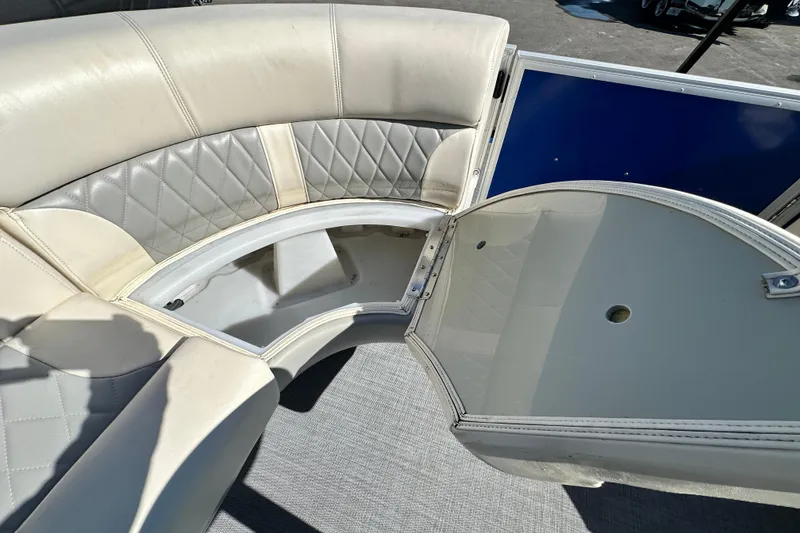 Slide: The Image of 2023 Lexington 321 CRUISE boat interior with open storage compartment and cushioned seating. - 29