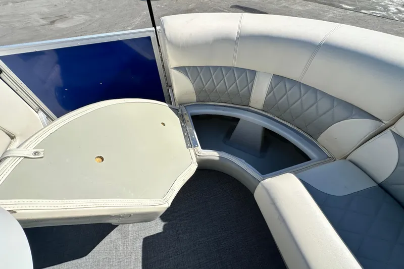 Slide: The Image of 2023 Lexington 321 CRUISE boat interior with cushioned seating and storage compartment. - 32