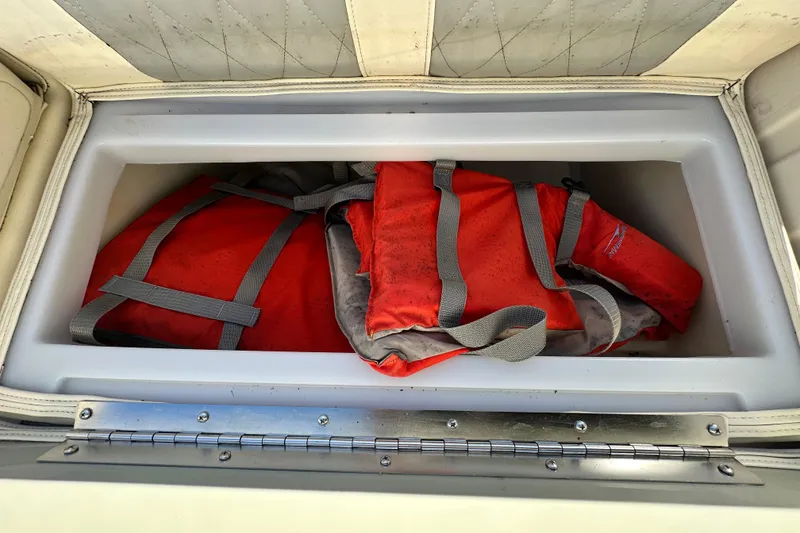 Slide: The Image of Red life jackets stored in a compartment of a 2023 Lexington 321 CRUISE boat. - 36