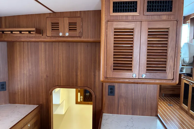 Slide: The Image of Interior of 2024 Helmsman Trawlers 43E Pilothouse with teak cabinetry and modern design. - 11