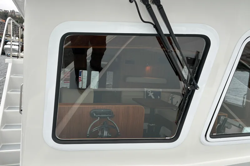Slide: The Image of 2024 Helmsman Trawlers 43E Pilothouse window and stairs to flybridge. - 61