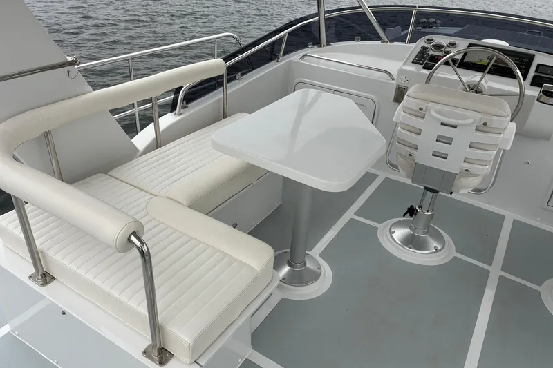 Slide: The Image of 2024 Helmsman Trawlers 43E PILOTHOUSE flybridge seating, table, and helm station. - 62