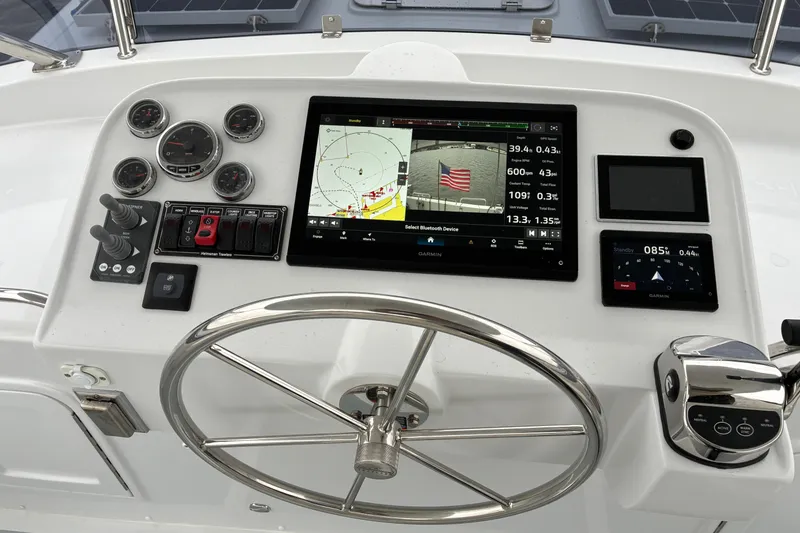 Slide: The Image of Helmsman Trawlers 43E PILOTHOUSE 2024 flybridge helm controls and monitors. - 64