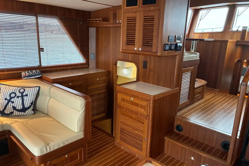 Slide: The Image of Luxurious interior of 2024 Helmsman Trawlers 43E Pilothouse with wood finish and cozy seating. - 9