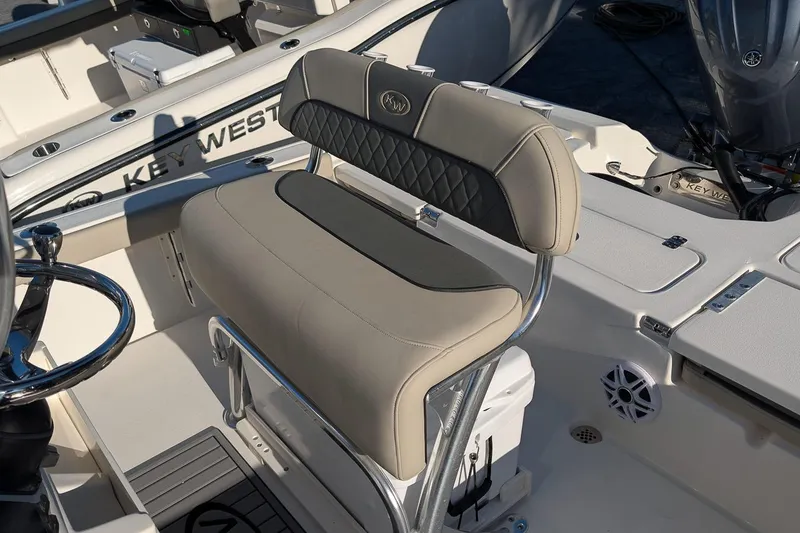 Slide: The Image of 2026 Key West 210 Bay Reef boat interior with beige seating and steering wheel. - 10