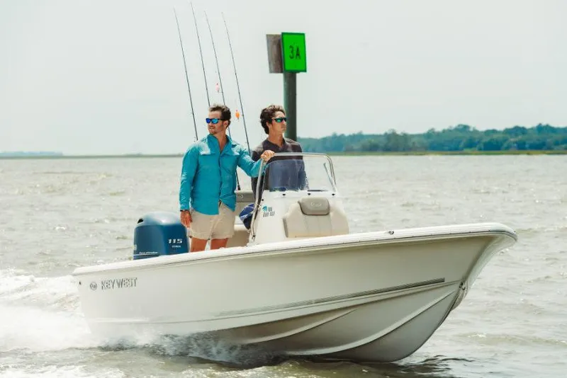 Slide: The Image of 2026 Key West 210 Bay Reef boat with Yamaha engine, parked on a trailer. - 2