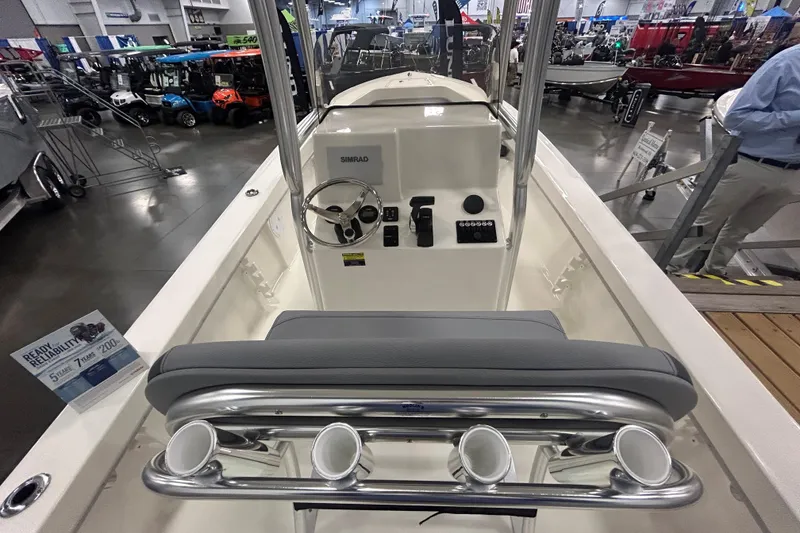 Slide: The Image of 2026 Maycraft 238CC boat interior with steering console and rod holders at a showroom. - 6
