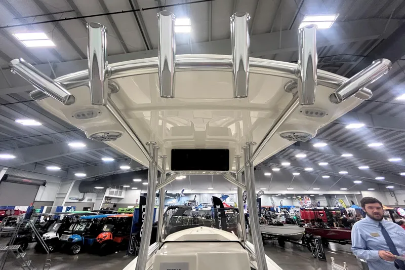 Slide: The Image of 2026 Maycraft 238CC boat with rod holders, displayed indoors at a boat show. - 7
