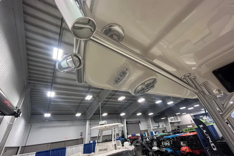 Slide: The Image of 2026 Maycraft 238CC boat interior with rod holders and speaker, displayed indoors. - 8