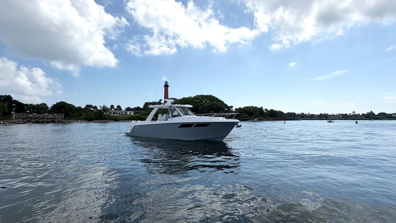 Slide: The Image of Intrepid 35 VALOR 2026 on calm water with a lighthouse and cloudy sky in the background. - 2