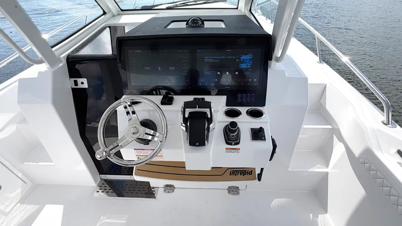 Slide: The Image of Intrepid 35 VALOR 2026: Modern cockpit with steering wheel, screens, and controls on calm water. - 22